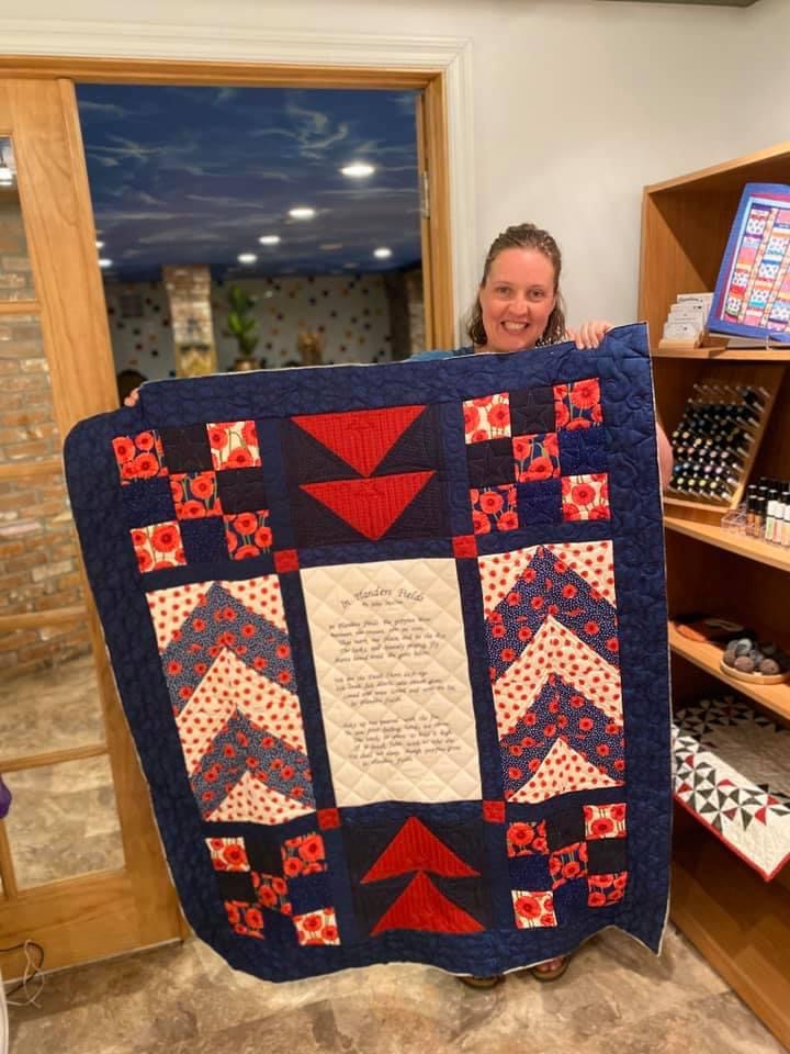 person holding a navy blue patterned quilt