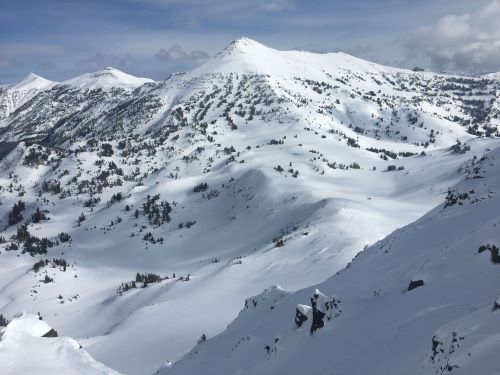 a wide angle shot of mountain top peak covered in snow
