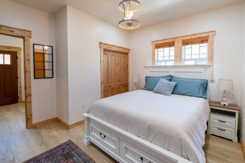 interior of the Bon Temps Suites featuring a queen size bed with white linens and teal pillows