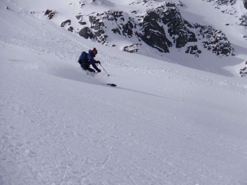 a close up of a downhill skier skiing in the backcountry