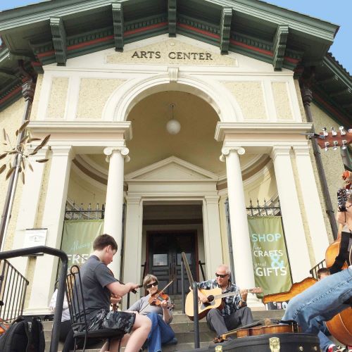 exterior of the Pendleton Center for the Arts with musician playing the guitar and violin