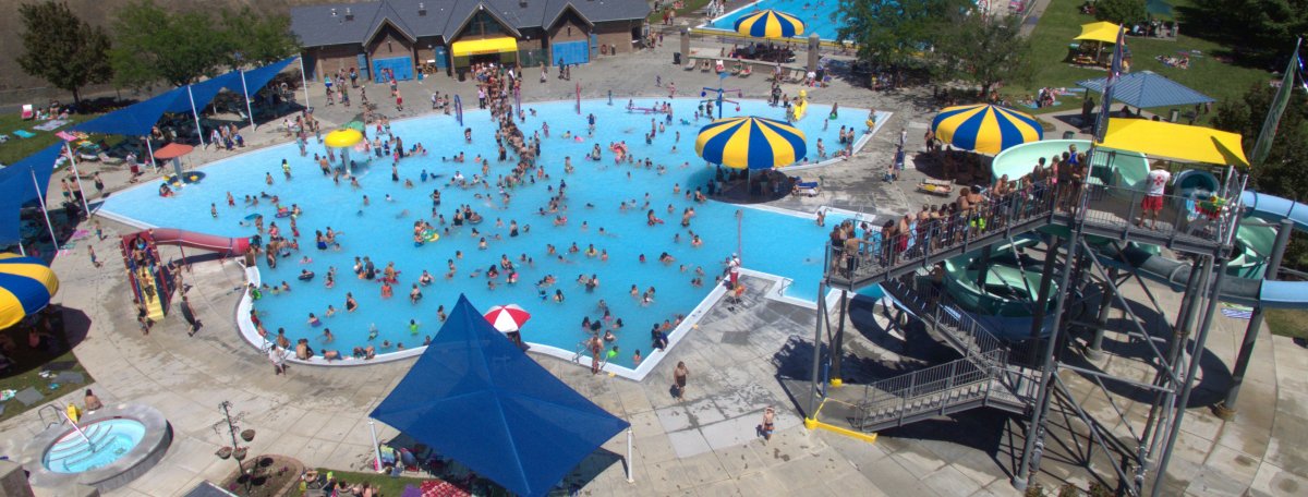 aerial view of the pendleton aquatic center includes views of the slide, blue shade tents, and yellow and blue umbrellas