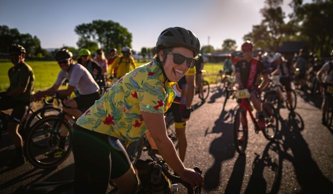 excited female cyclist smiles for the camera with her tongue out