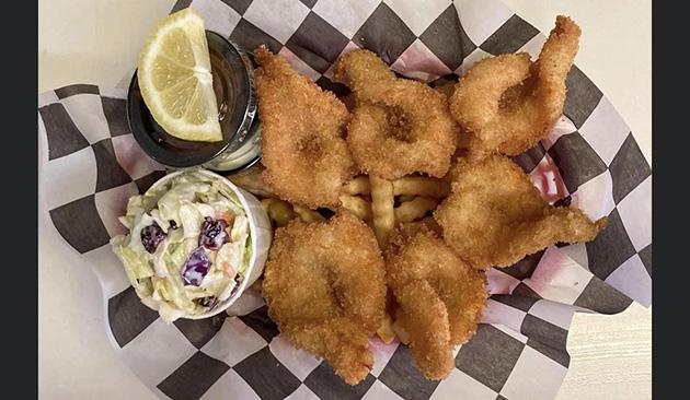 fish and chips on checkered paper in a basket with coleslaw