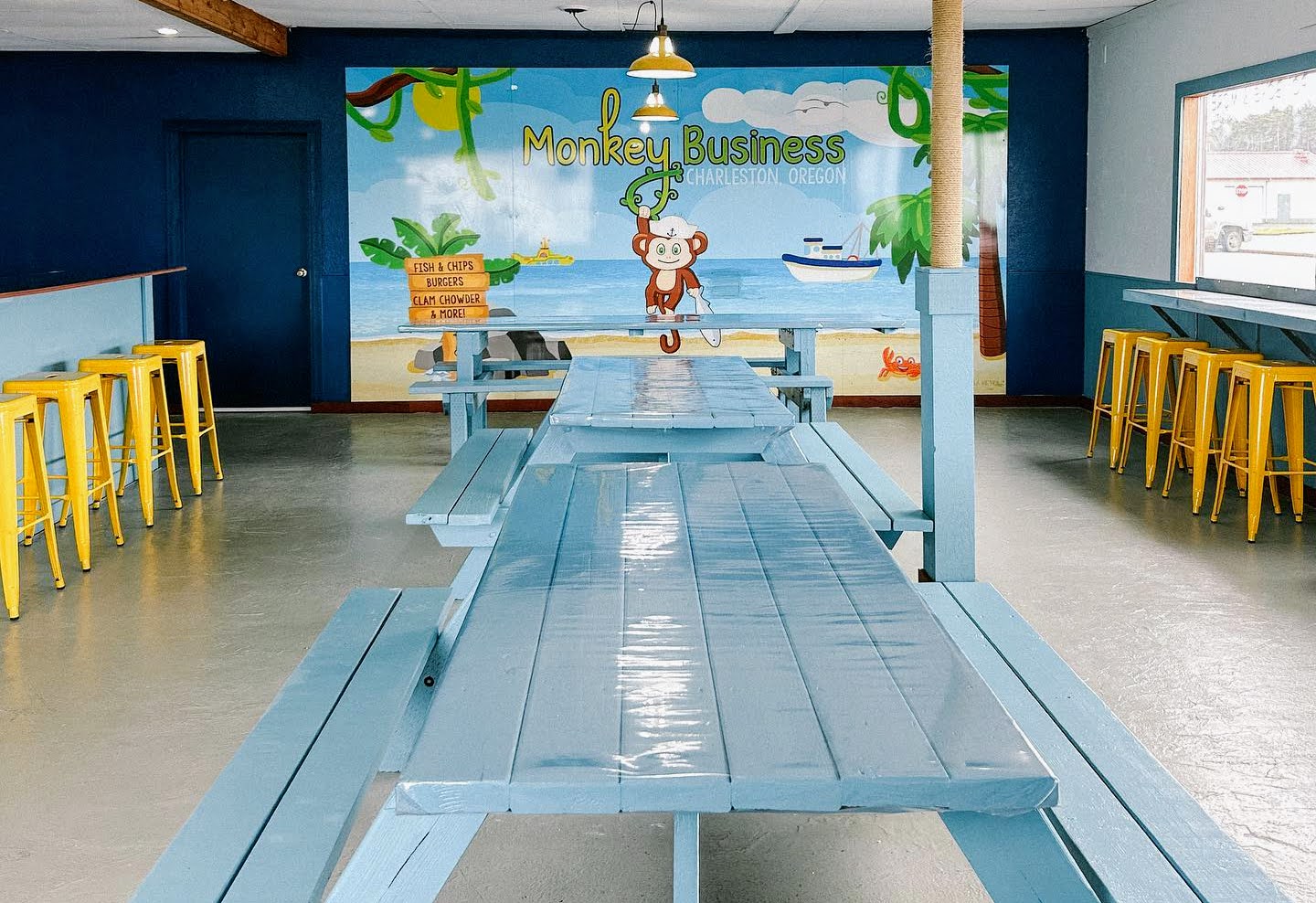 restaurant casual dining room with blue tables and yellow stools
