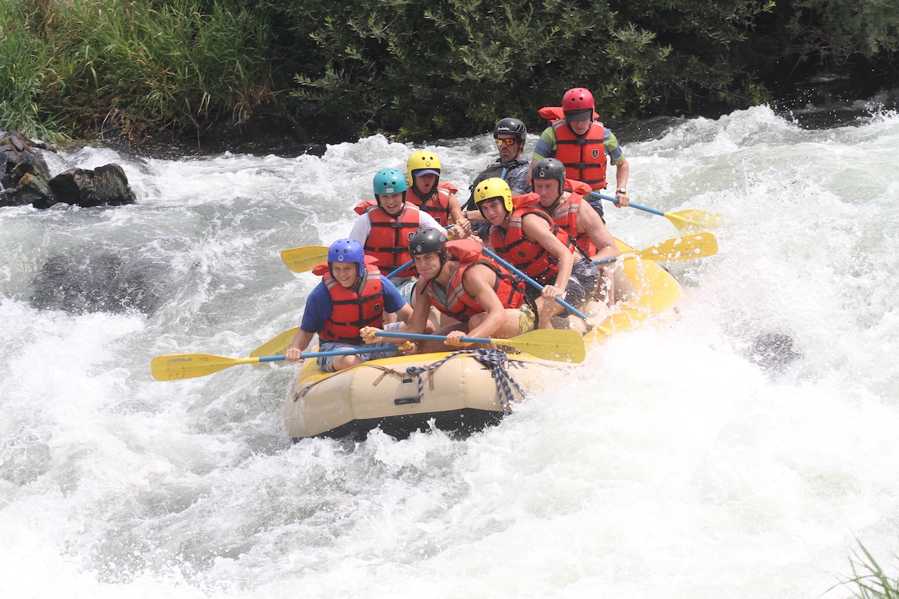 Raft on whitewater with rafters in lifejackets
