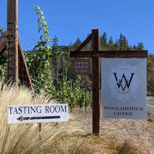 sign for Wooldridge Creek winery with smaller sign with arrow and lettering for tasting room