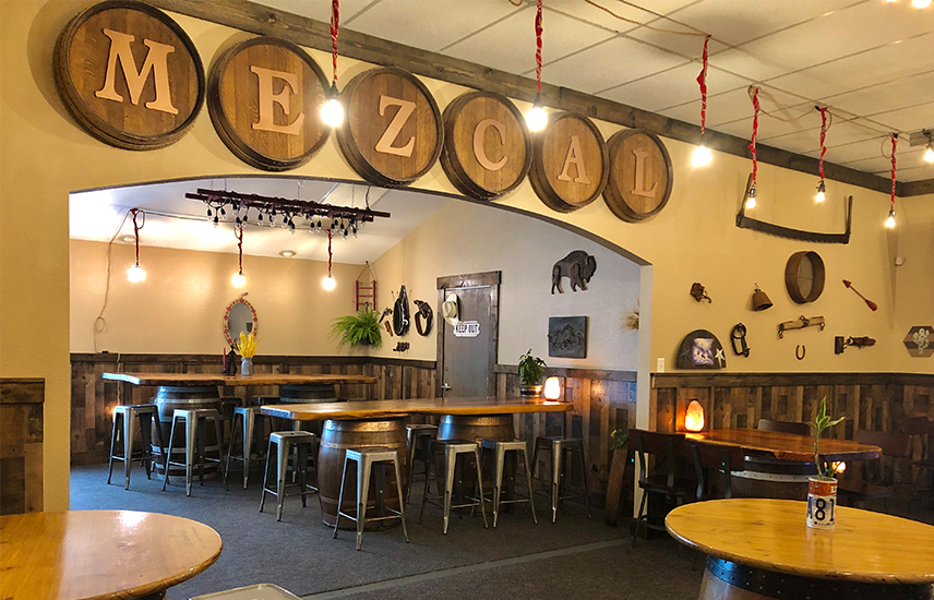 The dining room at Mezcal has long live edge tables and a western feel.