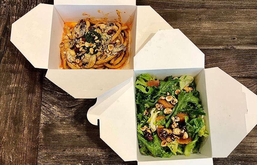 Two to-go containers filled with pasta and salad.