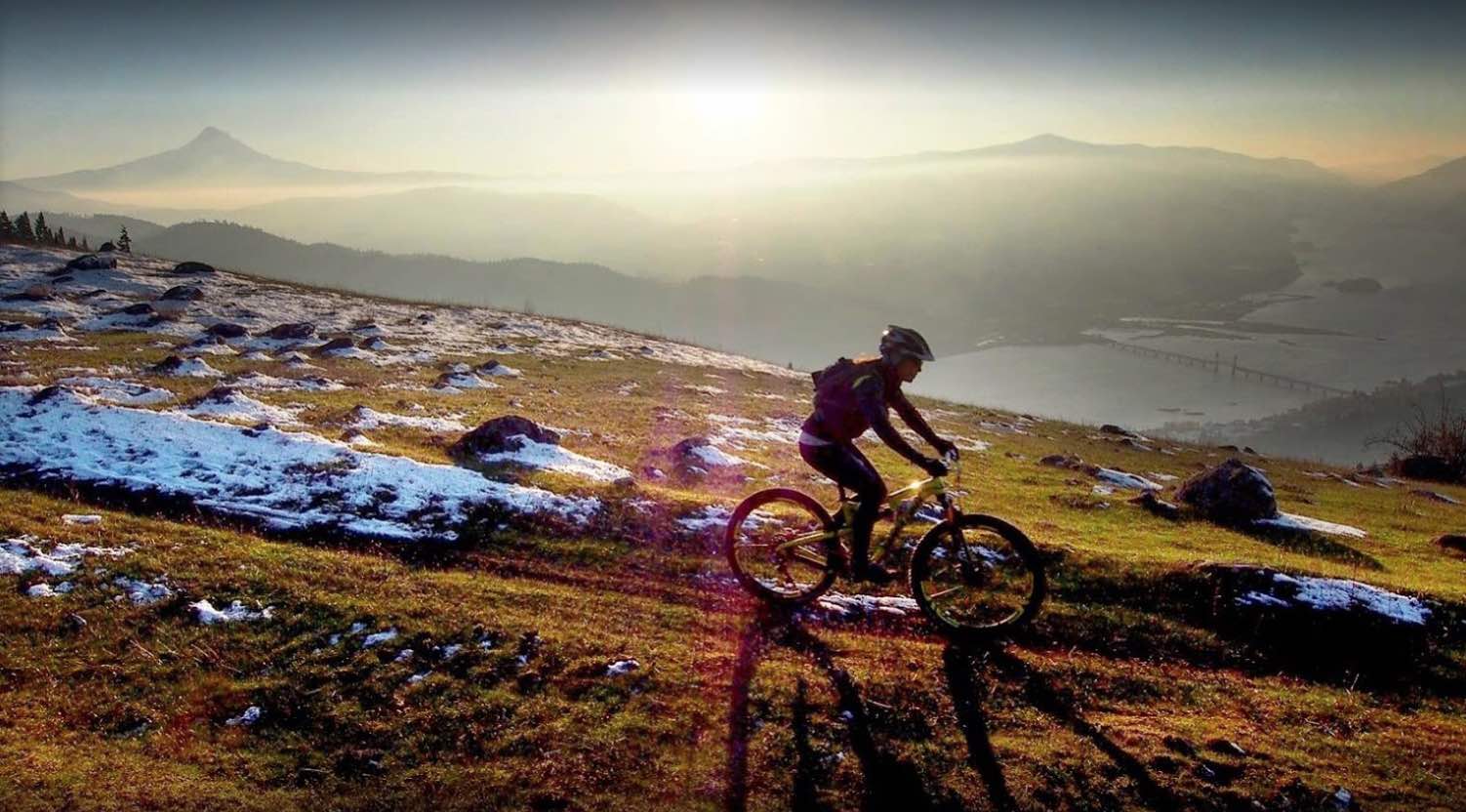 person rides mountain bike on a trail with a scenic view