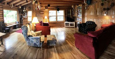 Living room with wooden floors and log cabin walls.