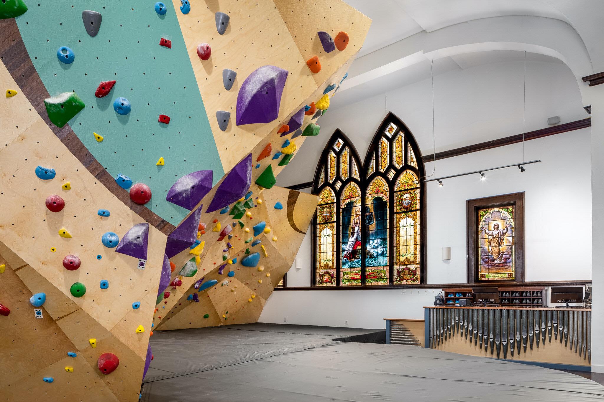 Climbing wall juxtaposed by church stained glass