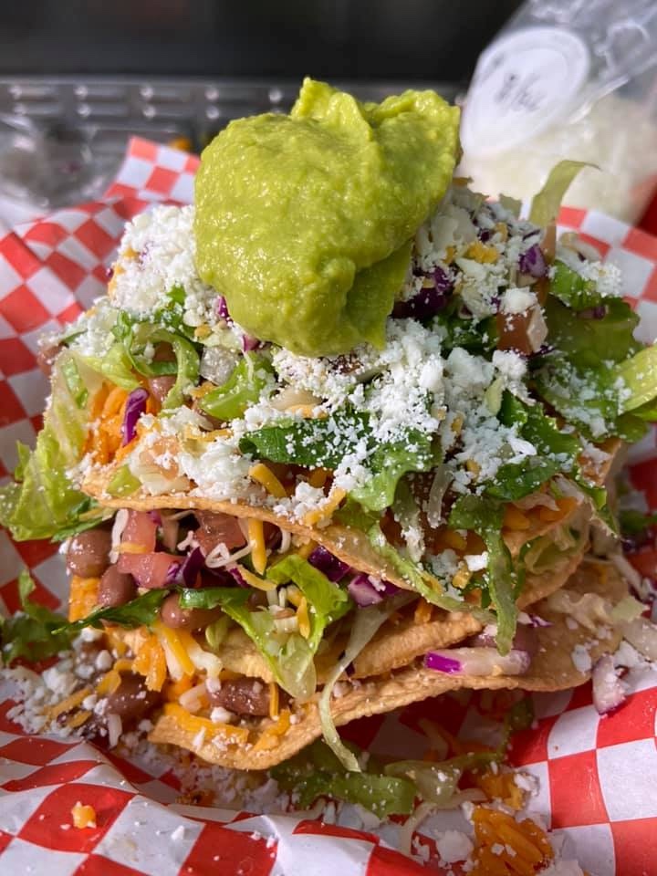 Mexican Tostada topped with cheese and guacamole