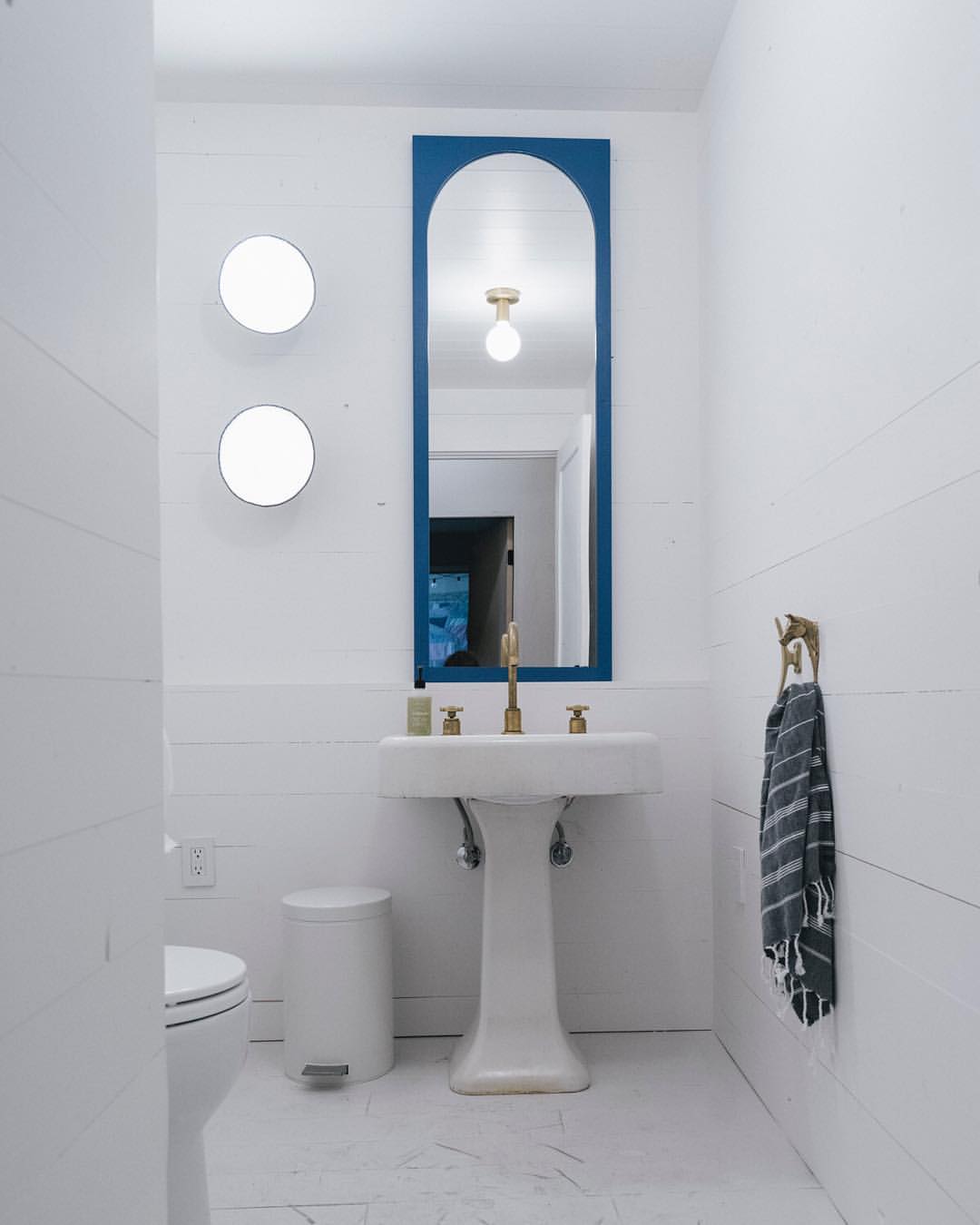 modern style bathroom with vertical mirror over a pedestal sink