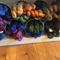 hanks of yarn displayed in buckets on their sides
