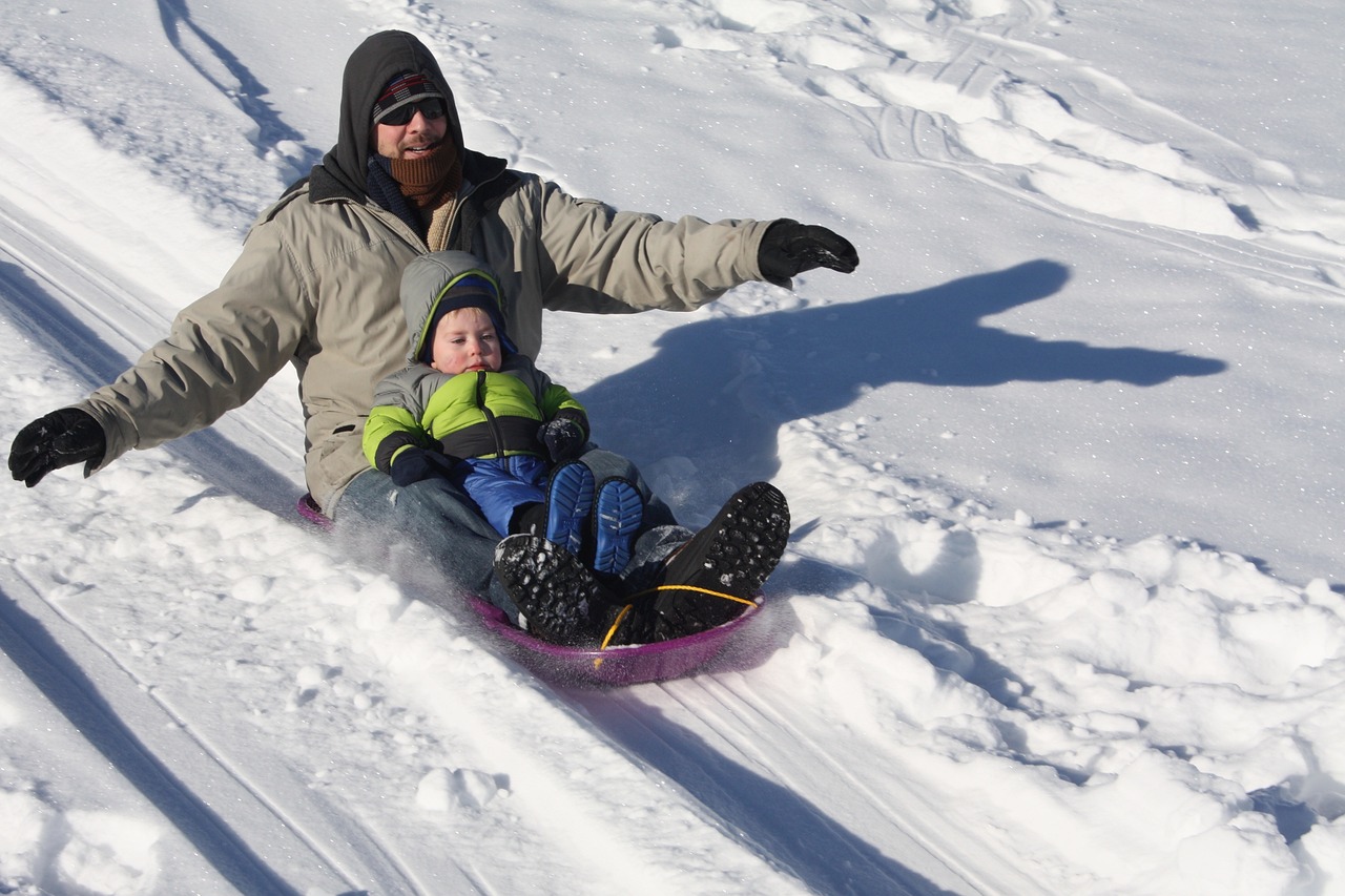 Father and child sledding