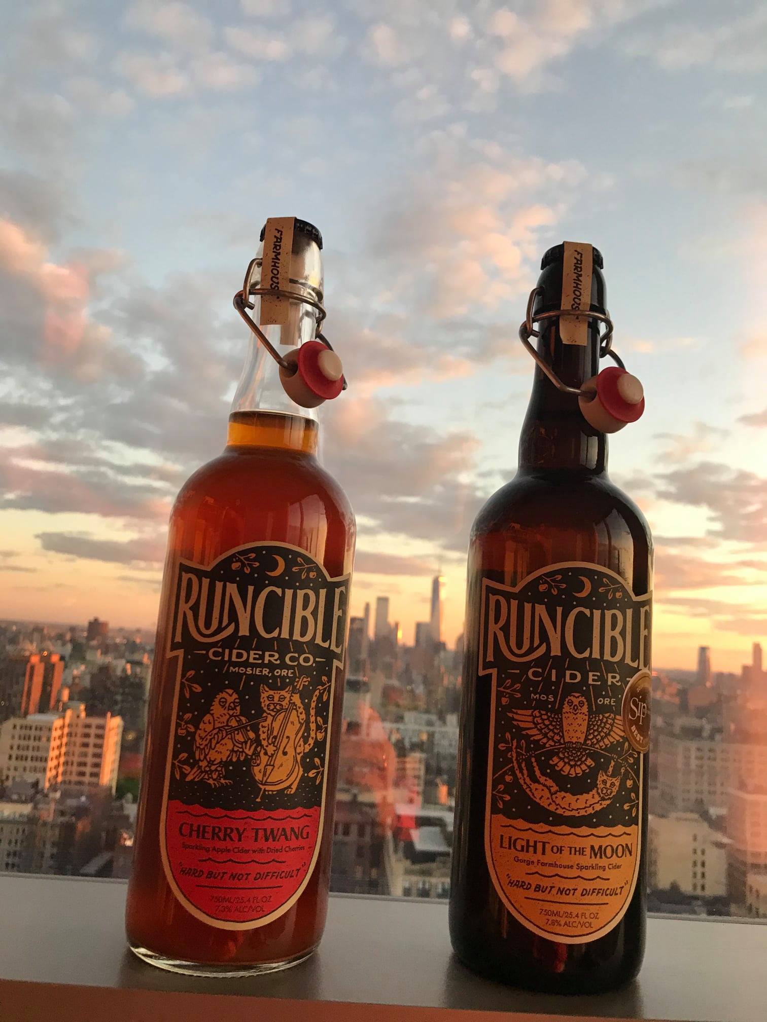 two bottles of runcible cider with city background