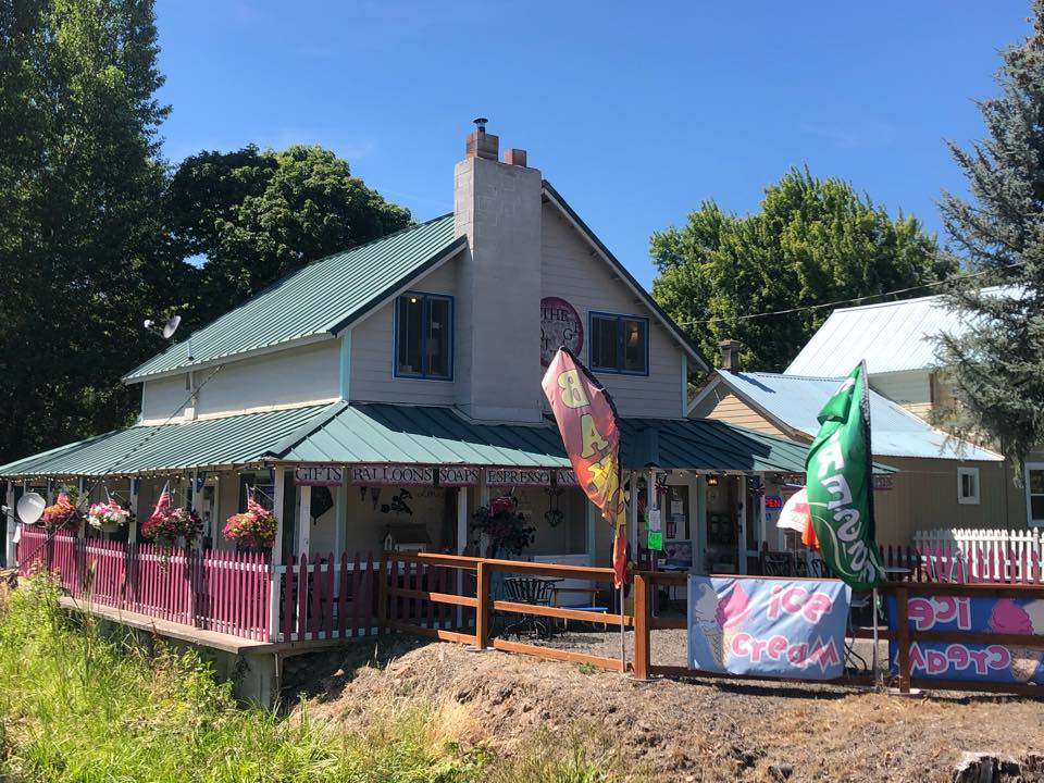 exterior of two story cottage with porch and banners in front