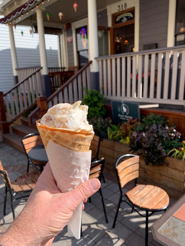 ice cream in hand infront of ice cream shop