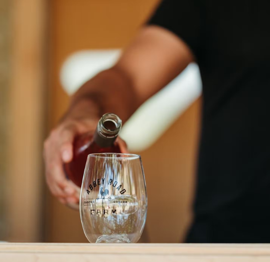 Server with wine at Abbey Road Farm