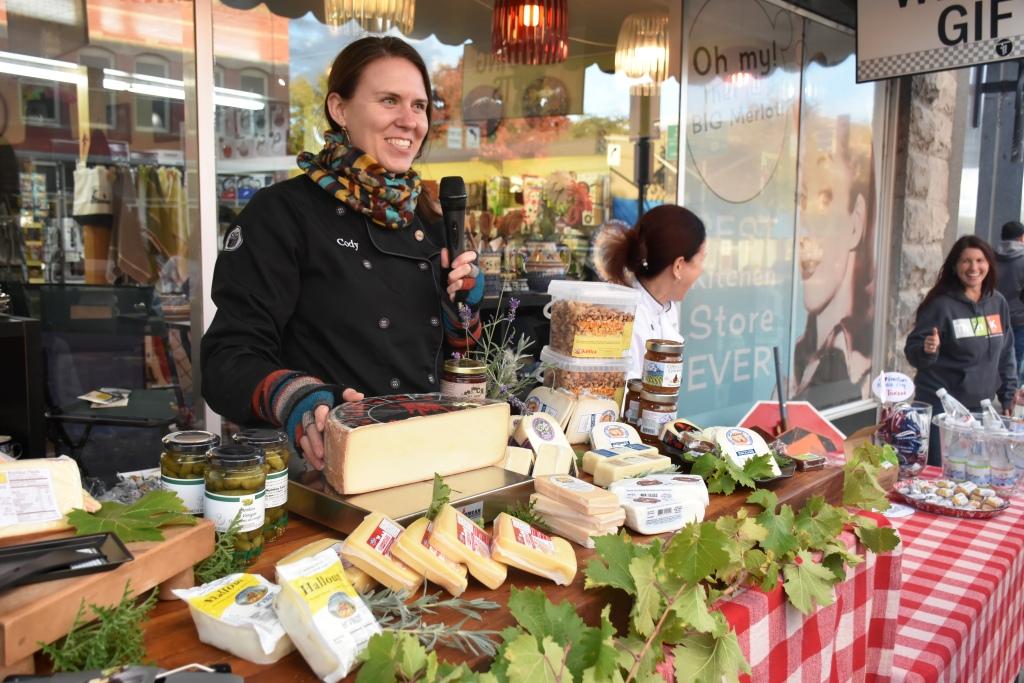 Vendor at outdoor both displaying a variety of cheeses.
