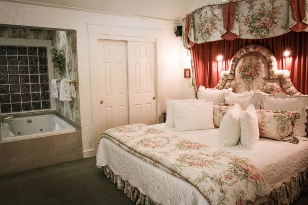 interior of hotel room with floral bedding and in room bathtub