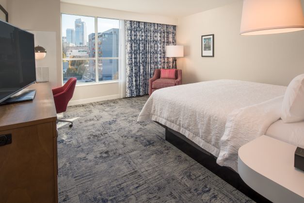 small hotel guestroom with view of city out window