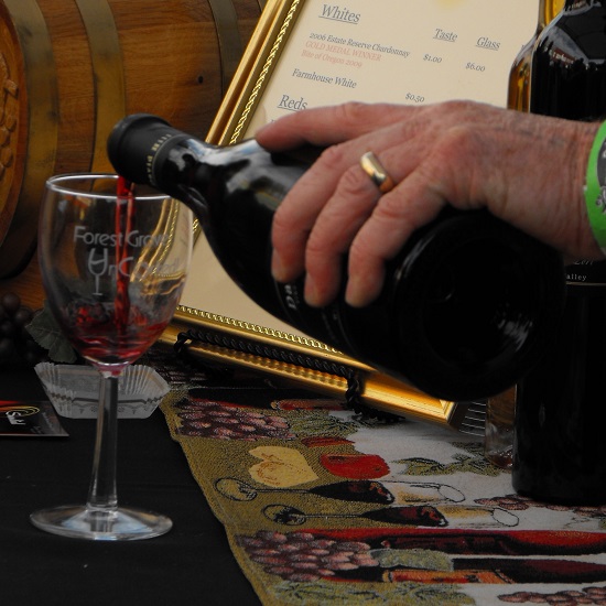 A vintner pouring a taste of Pinot Noir at Forest Grove Uncorked
