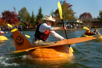 person floats in hollowed out giant pumpkin