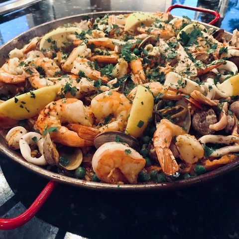 A seafood dish with shrimp in a big pot.