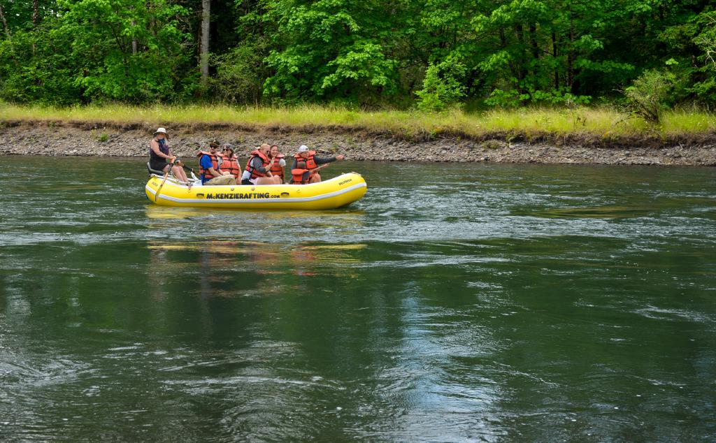 A group of people floating down a river on a raft.