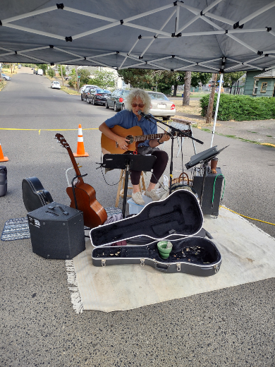 A person playing guitar at a farmer's market.