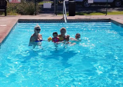 A family swimming in an outdoor swimming pool.