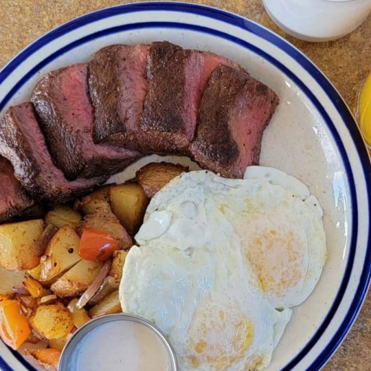 A plate of steak, eggs, and potatoes.