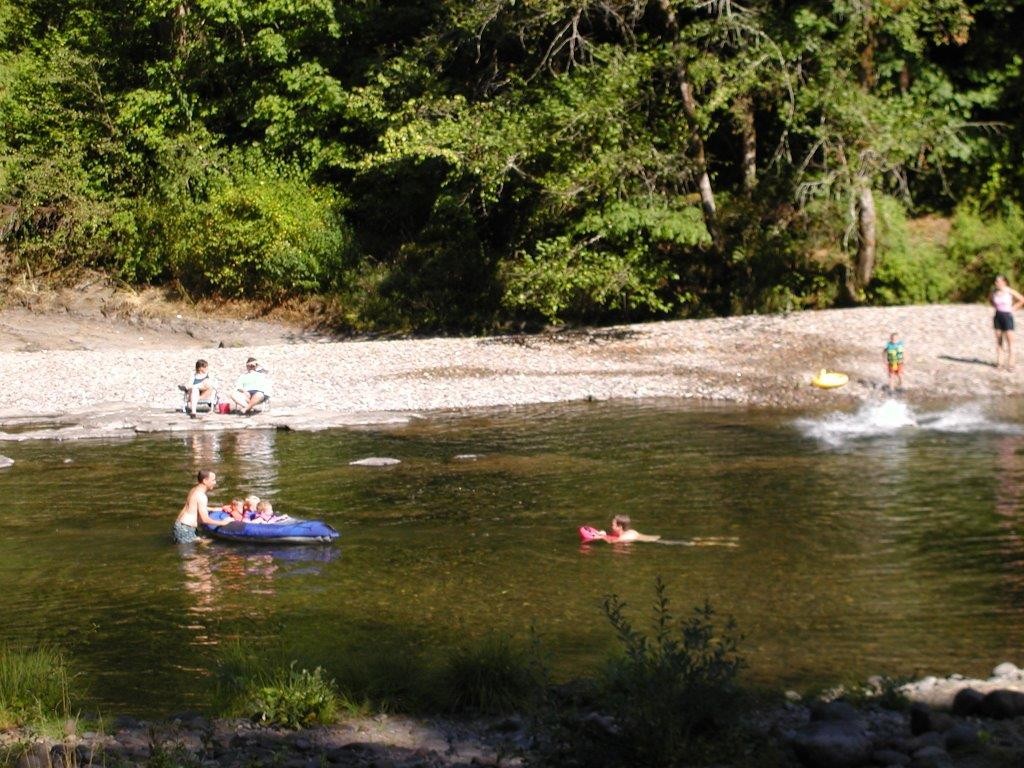 People swimming and tubing in a river.