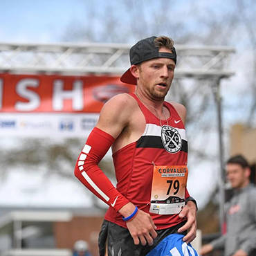 A man running with a hat during a half marathon.