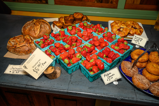 Fruit, bread, and pastries for sale.
