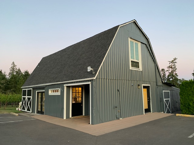 A grey barn that serves as a tasting room at Pudding River Wine Cellars.