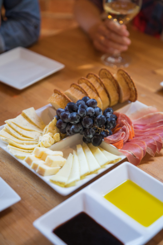 A cheese and meat board served with wine.