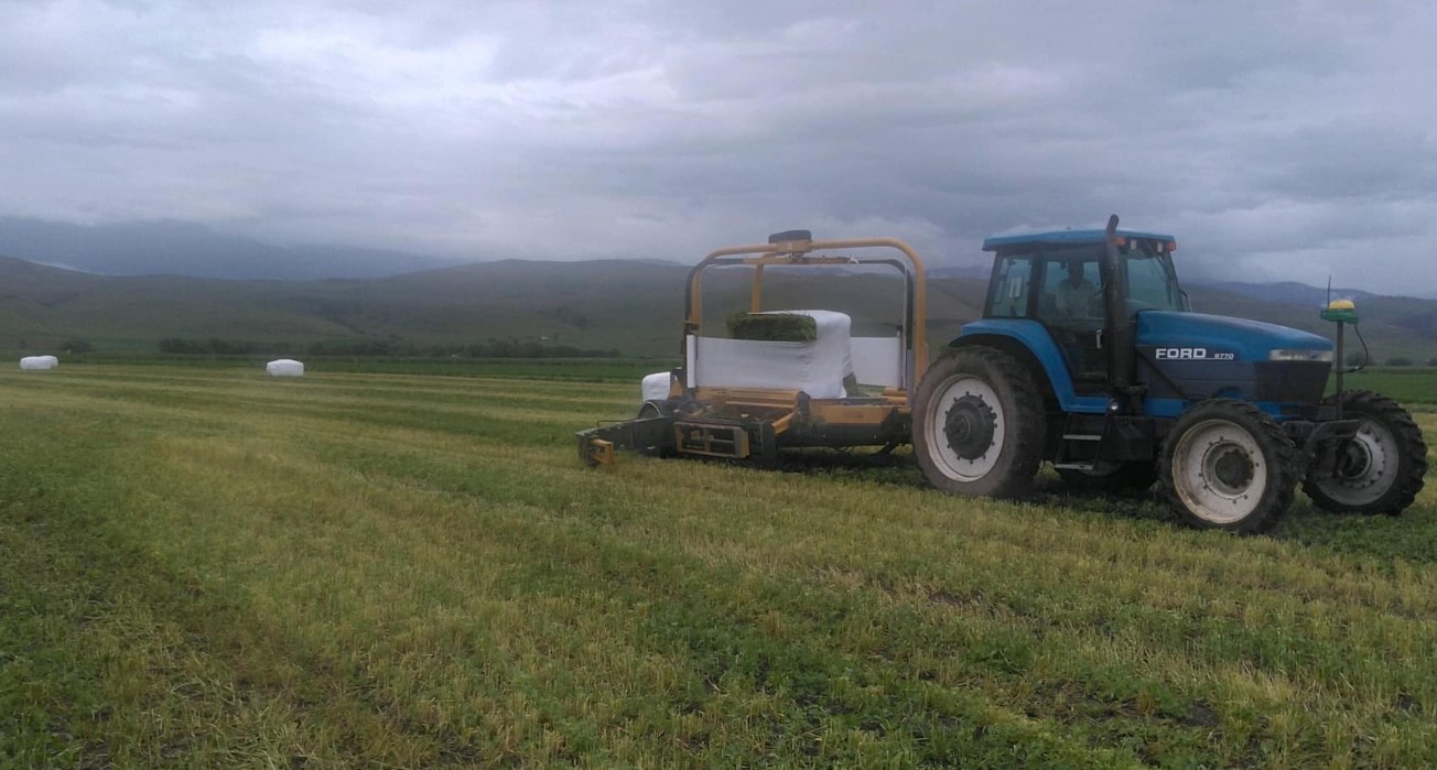 tractor in farm field under cloudy sky