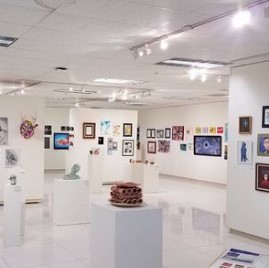 art gallery with pieces displayed on the wall as well as on stands