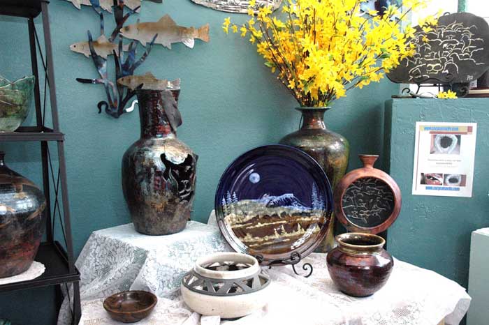 handmade clay vases, plates and bowls on display on table