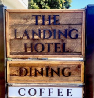wooden sign with lettering for The Landing Hotel Dining Coffee