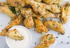 close up of chicken wings and cup of dipping sauce