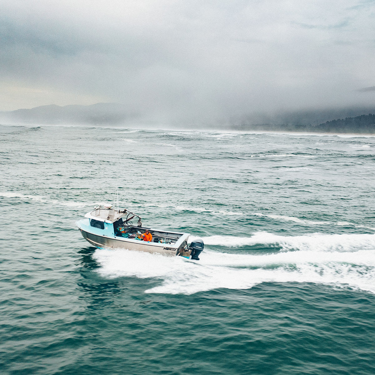 Ecola Seafoods fishing boat on the water under foggy clouds