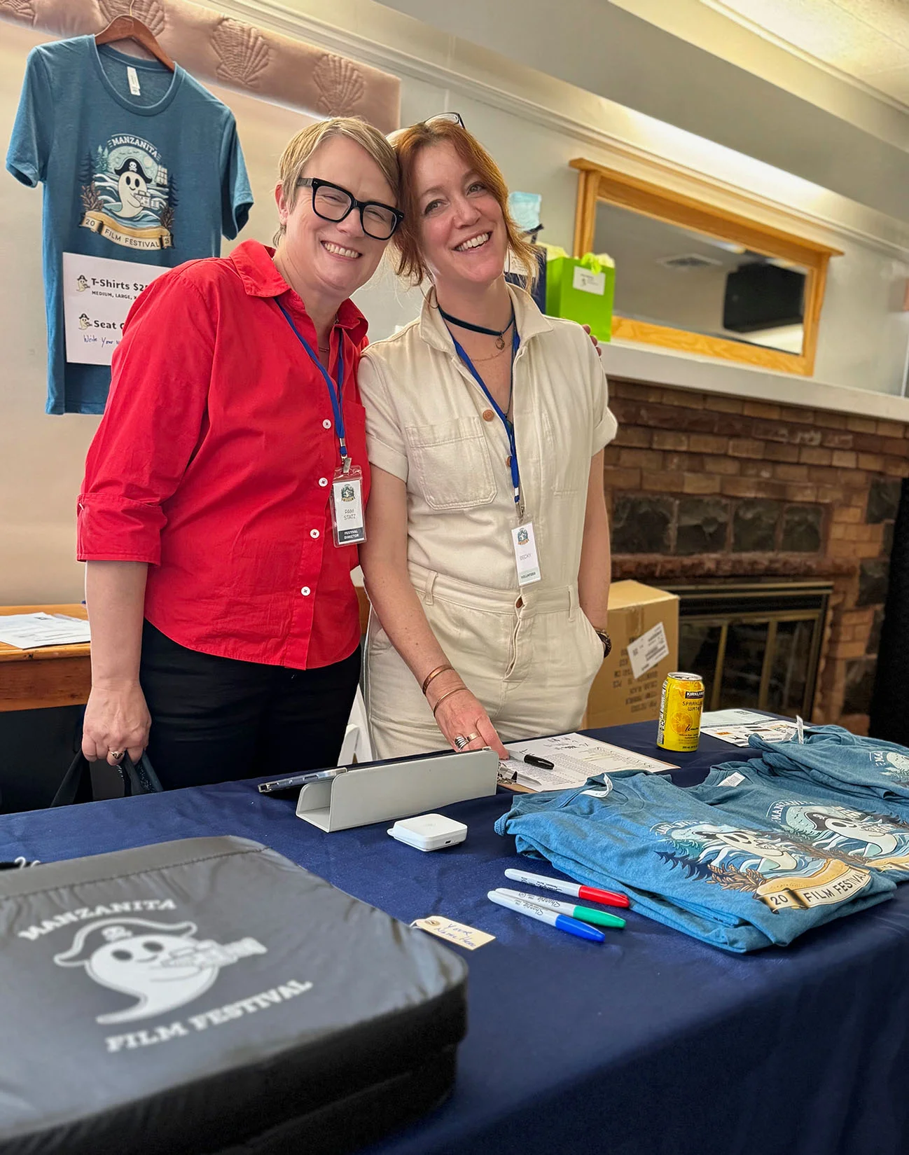 people smiling at merchandise table at the 2025 Manzanita Film Festival