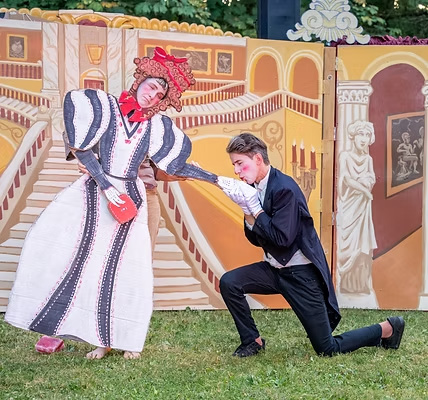Actors in performance playing gentleman kissing lady's hand