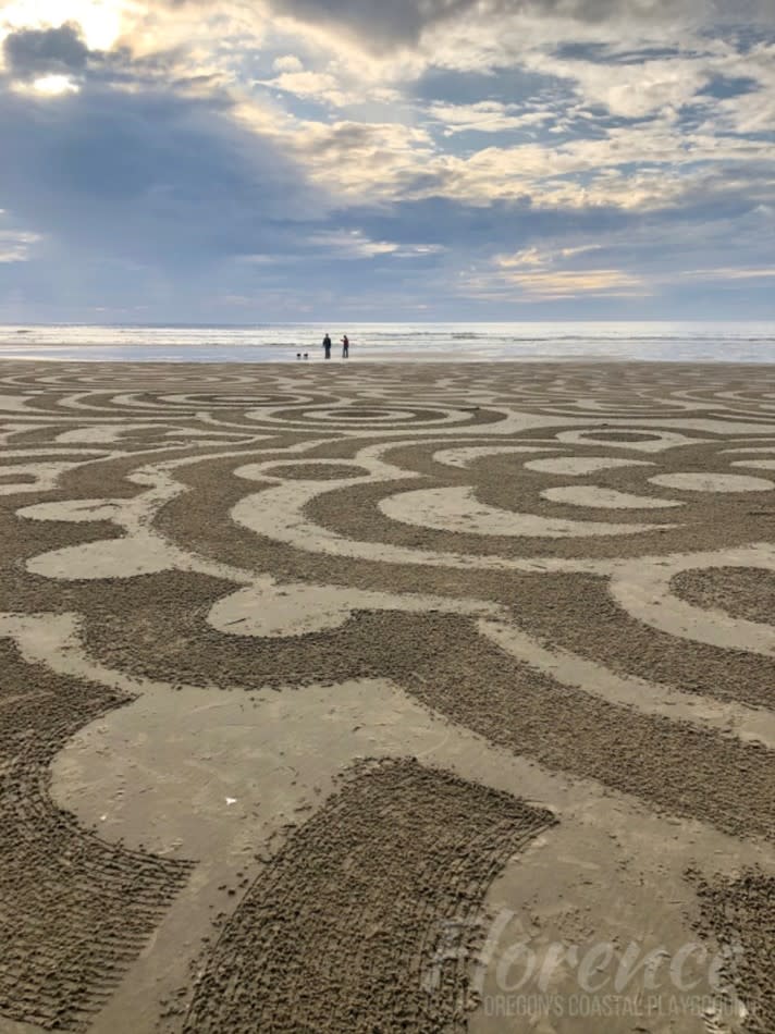 Sand circle art on Florence beach next to the ocean under sunny clouds