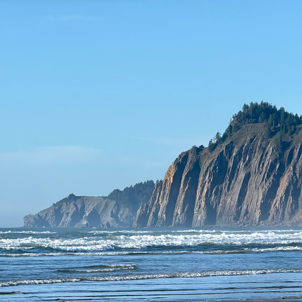Coastal cliffs in the distance with ocean waves below