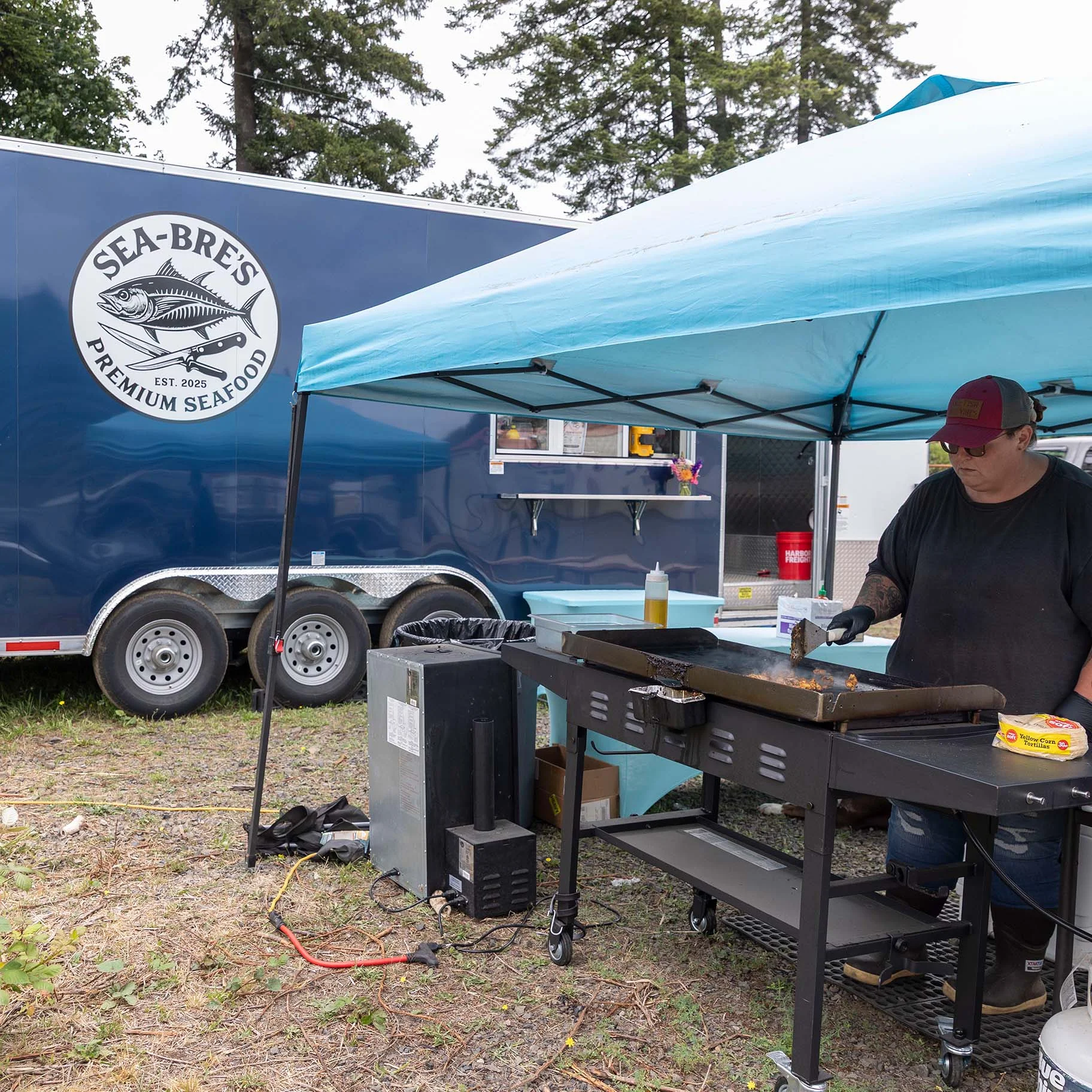 Bre cooking fish tacos at her mobile seafood processing cart in Toledo.jpg